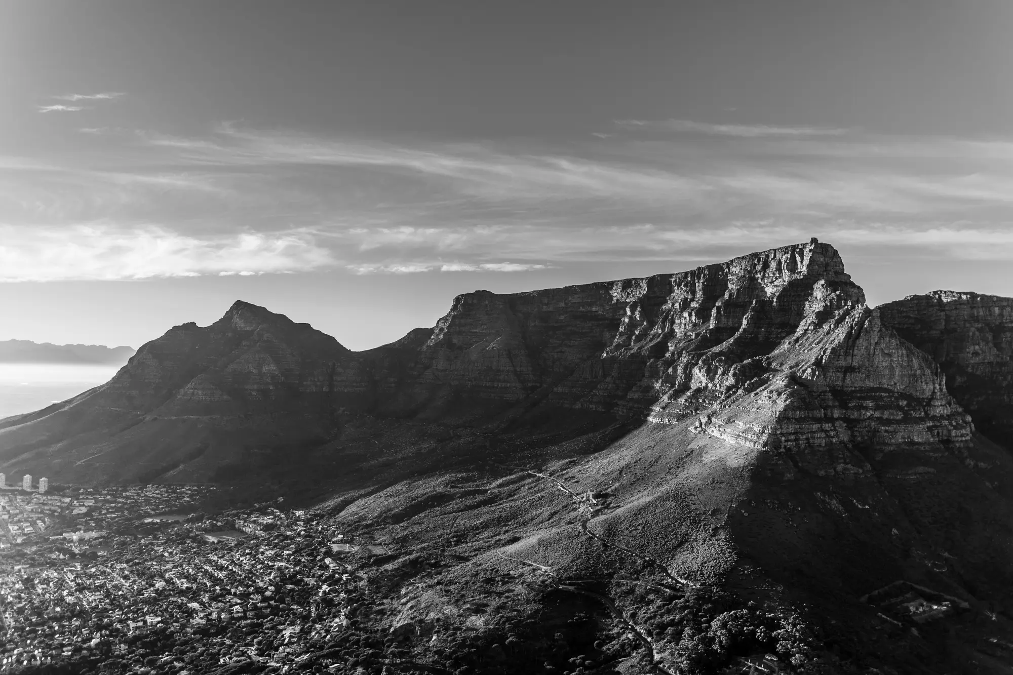 Monochrome view of Table Mountain and Devil's Peak at sunrise from Lion's Head, the city nestled below